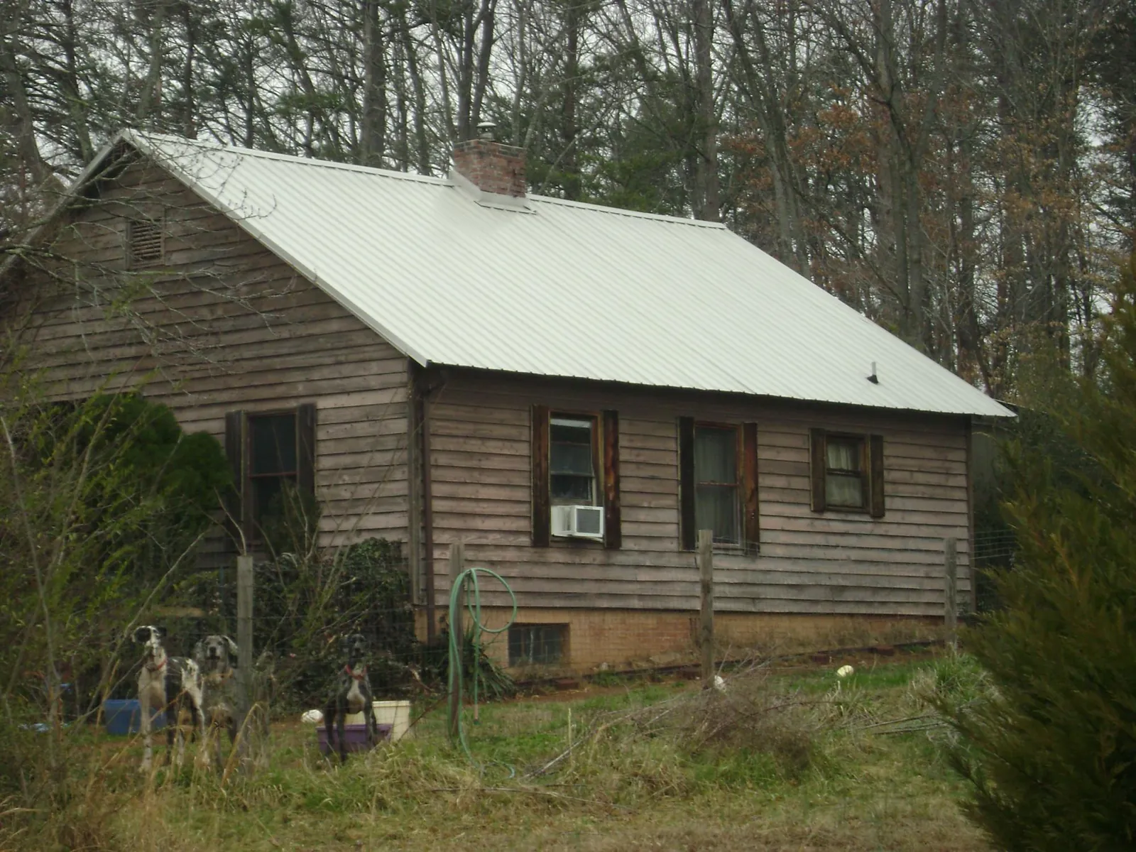 White metal roof on an old wood sided farmhouse, from a Metal Roof Installation job in Shawnee